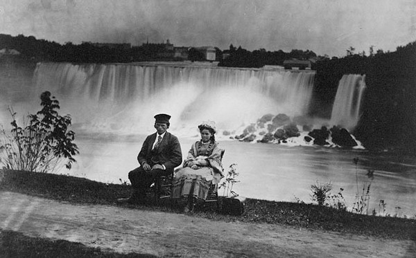 Young man and girl seated on the Canadian side of Niagara Falls